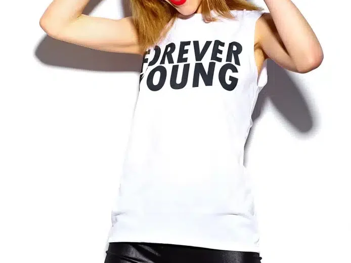 Eine fröhliche junge Frau mit individuellen Abschlusst-shirt der Abschlussklasse mit der Botschaft forever young